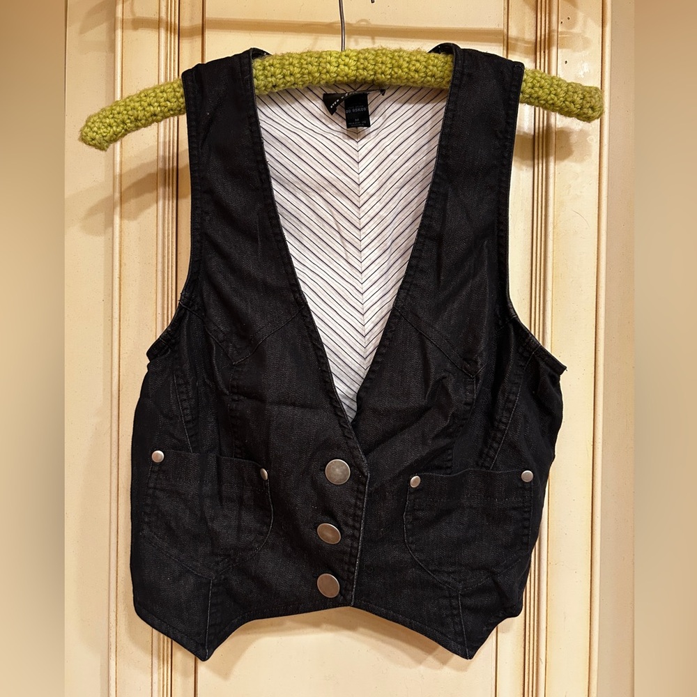 Black crop vest 64% cotton/34% polyester/2% spandex. Brushed metal buttons.